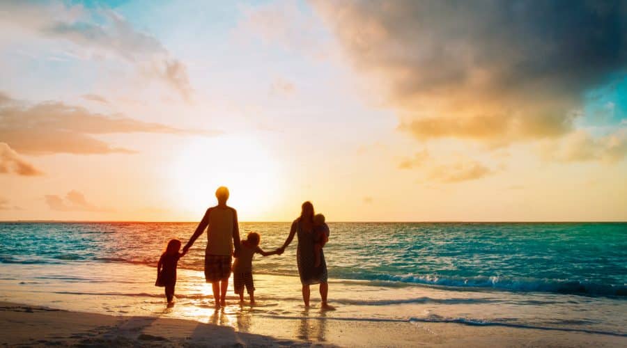 What is Estate Planning? A set of guidelines to help your family enforce your wishes. Image of a family walking along a beach.